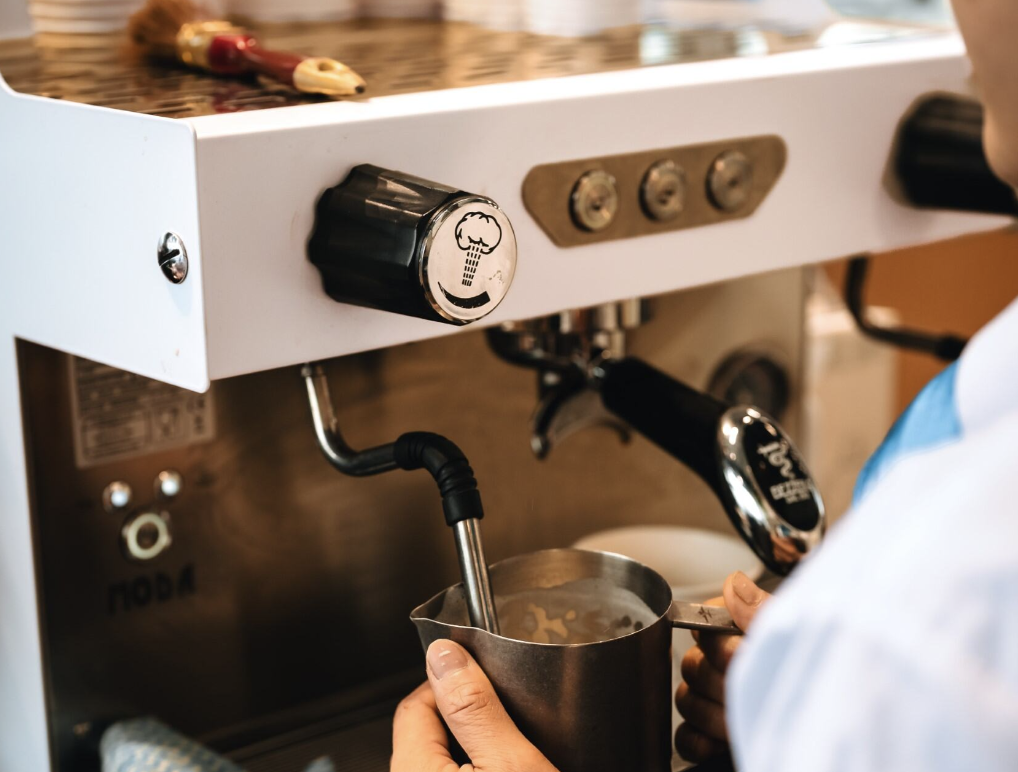 Latte Booth Barista Frothing Milk for a Latte